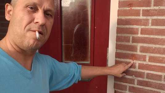 Martin Kok pokazuje ostrzelana fasade domu.