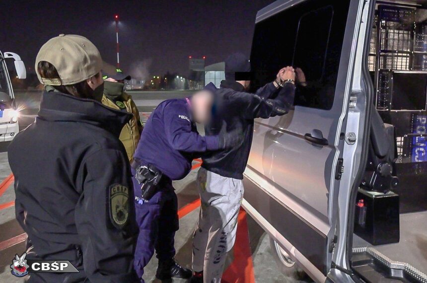 Policjanci prowadzący zatrzymanego szefa grupy przestępczej znanej jako gang Smoka.