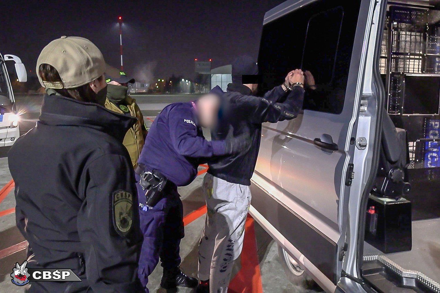 Policjanci prowadzący zatrzymanego szefa grupy przestępczej znanej jako gang Smoka.