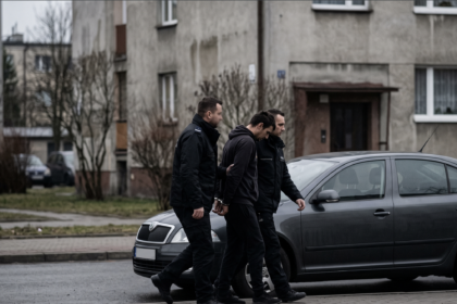 Policja prowadząca zatrzymanego Bułgara [Zdjęcie wygenerowane w AI]