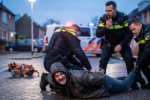 Mężczyzna zakuwany w kajdanki przez policje na ziemi [Zdjęcie wygenerowane w AI]